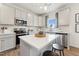 Modern kitchen with white cabinets, stainless steel appliances, a central island, and hardwood floors at 27 Cribbs Ln, Middlesex, NC 27557