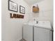 Functional laundry room with a washing machine, dryer, and storage shelf with the word 