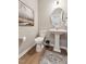 Well-lit powder room featuring a pedestal sink, round mirror, and tasteful wall art at 27 Cribbs Ln, Middlesex, NC 27557