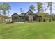 Rear view of home featuring a lush lawn and inviting screened in patio with stone fireplace at 285 Mollie Meadow Dr, Zebulon, NC 27597