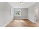 Bright bedroom with hardwood floors, a large window for natural light, and a glimpse into the bathroom at 285 Mollie Meadow Dr, Zebulon, NC 27597