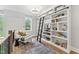 Stylish living room featuring a large bookshelf with a ladder, a comfortable chair, and ample natural light at 285 Mollie Meadow Dr, Zebulon, NC 27597