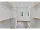 Bright walk-in closet with hardwood floors, custom shelving and cabinetry, and natural light at 285 Mollie Meadow Dr, Zebulon, NC 27597