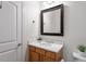 Bathroom featuring wood cabinets, modern fixtures and a framed mirror at 317 W Morgan St # 320, Raleigh, NC 27601