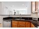 Open kitchen featuring wood cabinets, black countertops and stainless steel dishwasher at 317 W Morgan St # 320, Raleigh, NC 27601