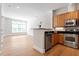 Sunlit kitchen featuring stainless steel appliances and wood cabinets overlooking a spacious living area at 317 W Morgan St # 320, Raleigh, NC 27601