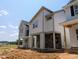 Modern two-story home with brick foundation, gray siding, and covered porch, set against a clear blue sky at 330 Cottage Hill Way, Knightdale, NC 27604