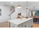Open-concept kitchen view with staircase, island seating, and modern pendant lighting at 330 Cottage Hill Way, Knightdale, NC 27604