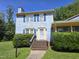 Charming blue two-story home with yellow trim, blue shutters, brick steps, and green landscaping at 3510 Rawdon Dr, Durham, NC 27713