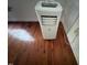 Image of a white air conditioning unit with a cord plugged into the wall, sitting on a hardwood floor at 358 Pool Rock Shores Ln, Henderson, NC 27537