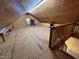 Spacious attic features wood-paneled walls and floors, a small window, and a staircase leading up at 358 Pool Rock Shores Ln, Henderson, NC 27537