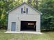 Exterior shows neutral-colored garage with an open door and surrounded by green foliage at 358 Pool Rock Shores Ln, Henderson, NC 27537