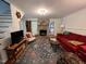 Comfortable living room with a stone fireplace, colorful rug, and a blend of furniture styles at 358 Pool Rock Shores Ln, Henderson, NC 27537