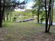 Scenic view of a lake with a wooden pier extending into the water, surrounded by lush greenery and trees at 358 Pool Rock Shores Ln, Henderson, NC 27537