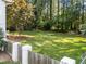 Expansive backyard featuring lush green grass, mature trees, and a charming wooden fence for privacy at 3620 Arrowwood Dr, Raleigh, NC 27604