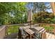 Outdoor deck furnished with a wooden table and chairs, surrounded by lush greenery at 3620 Arrowwood Dr, Raleigh, NC 27604