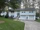 Well-maintained home featuring an attached two-car garage, a front yard, and mature trees at 3620 Arrowwood Dr, Raleigh, NC 27604