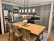 Bright kitchen featuring gray cabinets, subway tile backsplash, and a butcher block island with seating at 3620 Arrowwood Dr, Raleigh, NC 27604