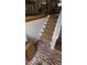 Staircase featuring sisal carpet, brick flooring, and wooden accents at 3620 Arrowwood Dr, Raleigh, NC 27604