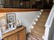 Staircase featuring sisal carpet, brick flooring, and wooden accents with a small cabinet at 3620 Arrowwood Dr, Raleigh, NC 27604