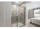 Contemporary bathroom with a glass-enclosed shower and neutral tones, adjacent to a serene bedroom space at 408 Grand Silo Rd, Garner, NC 27603