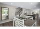 Contemporary dining area featuring a wooden table and seating adjacent to an open-concept kitchen and staircase at 408 Grand Silo Rd, Garner, NC 27603