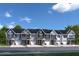Row of new townhomes with varied siding, garages and manicured landscaping at 408 Grand Silo Rd, Garner, NC 27603