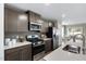 Modern kitchen features stainless steel appliances, gray cabinets, and quartz countertops at 408 Grand Silo Rd, Garner, NC 27603