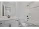 Clean bathroom showcasing a tub-shower combo, toilet, and vanity with white cabinetry and a framed mirror at 412 Longleaf Glen Lane, Zebulon, NC 27597