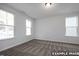 Bright, carpeted bedroom with three windows providing ample natural light and a view of the surrounding greenery at 412 Longleaf Glen Lane, Zebulon, NC 27597