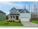 Charming two-story home with a manicured lawn, a welcoming porch, and a two-car garage at 412 Longleaf Glen Lane, Zebulon, NC 27597
