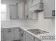Bright kitchen features gray cabinets, white countertops, and stainless steel appliances at 412 Longleaf Glen Lane, Zebulon, NC 27597