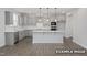 Modern kitchen with gray cabinets, a center island, stainless steel appliances, and hardwood floors, perfect for cooking at 412 Longleaf Glen Lane, Zebulon, NC 27597