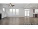 Open-concept living room with hardwood floors, a fireplace, built-in cabinets, and French doors leading to the outdoors at 412 Longleaf Glen Lane, Zebulon, NC 27597