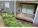 This back porch has a wood floor, a wooden lattice surround and a view of overgrown weeds at 4120 Sedgewood Dr # 106, Raleigh, NC 27612
