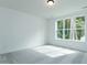 A clean and well-lit carpeted bedroom features a large window providing lots of light at 46 Addison Pond Ct, Zebulon, NC 27597