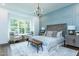 Comfortable bedroom with accent wall, sitting area, soft rug, a wooden headboard and a decorative chandelier at 46 Addison Pond Ct, Zebulon, NC 27597