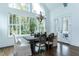 Bright dining room features a rustic wood table set, large windows, and a stylish chandelier fixture at 46 Addison Pond Ct, Zebulon, NC 27597
