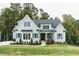 Charming light-blue home with manicured lawn, covered porch, and tasteful landscaping at 46 Addison Pond Ct, Zebulon, NC 27597