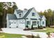 Light-blue home featuring a three-car garage, elegant landscaping, and charming shutters at 46 Addison Pond Ct, Zebulon, NC 27597
