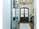 Elegant foyer with glass doors, hardwood floors, console table, and decorative mirror at 46 Addison Pond Ct, Zebulon, NC 27597