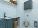 Functional laundry room features built-in sink, countertop, basket storage and upper cabinets at 46 Addison Pond Ct, Zebulon, NC 27597