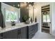 Elegant bathroom with double vanity, sleek fixtures, and view into bedroom with chandelier at 476 Mollie Meadow Dr, Zebulon, NC 27597