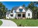 Beautiful two-story white home with a well-manicured lawn and lush landscaping on a sunny day at 476 Mollie Meadow Dr, Zebulon, NC 27597