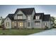 Charming two-story home with craftsman style architecture, inviting porch, and manicured lawn at twilight at 476 Mollie Meadow Dr, Zebulon, NC 27597