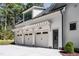 Three-car garage with white doors and a matching white exterior with black trim at 476 Mollie Meadow Dr, Zebulon, NC 27597