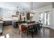 Modern kitchen with an island, pendant lighting, and a dining area with a large wooden table and chairs at 476 Mollie Meadow Dr, Zebulon, NC 27597