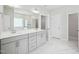 This bathroom has double sinks, white cabinetry, a large mirror, and marble floors at 514 Bonville Ct, Fuquay Varina, NC 27526
