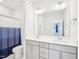 This modern bathroom features dual sinks, gray cabinetry, and a stylish shower curtain at 514 Bonville Ct, Fuquay Varina, NC 27526