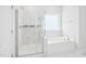 Bright bathroom features a separate glass shower and soaking tub at 514 Bonville Ct, Fuquay Varina, NC 27526